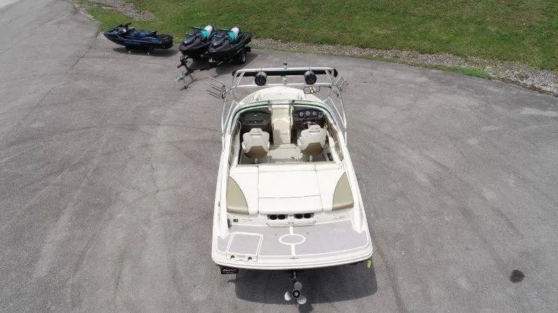 Slide: The Image of 2007 Sea Ray 210 Select boat parked on pavement with jet skis nearby. - 7