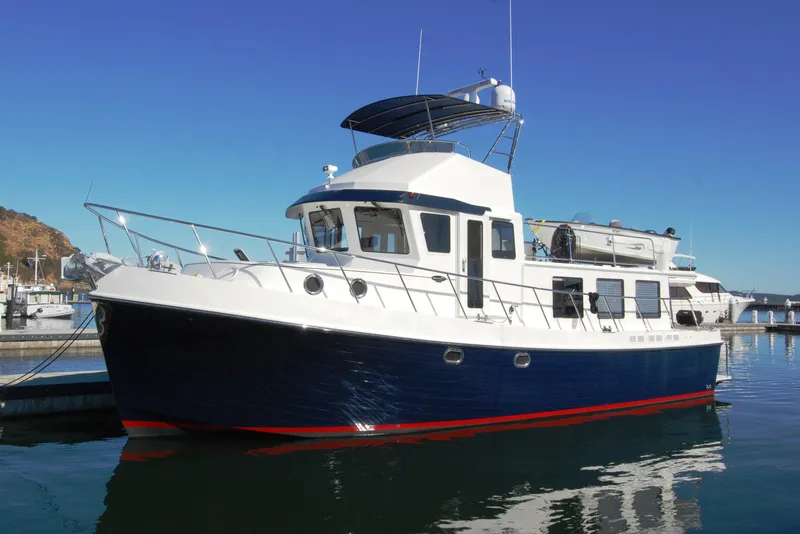 The Image of American Tug 485, 2015 model, docked in a marina under clear blue skies. - 0