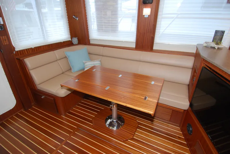 Slide: The Image of Interior of 2015 American Tug 485 with wood table and beige seating. - 16