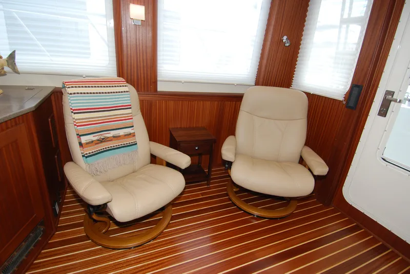 Slide: The Image of Interior of 2015 American Tug 485 with beige chairs and striped blanket. - 18