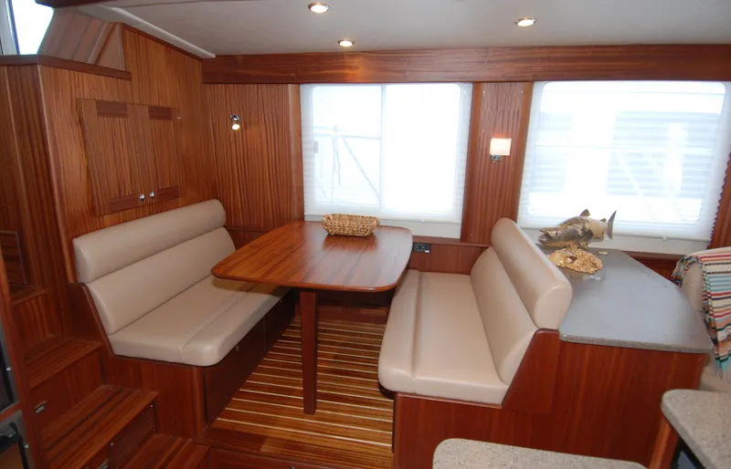 Slide: The Image of Interior of 2015 American Tug 485 with wood paneling and cozy dining area. - 26