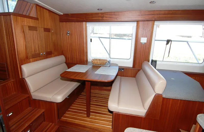 Slide: The Image of Interior of 2015 American Tug 485 with wooden dining area and beige seating. - 29