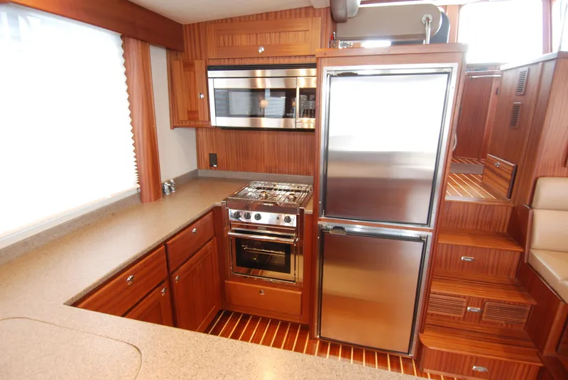 Slide: The Image of Luxurious kitchen in 2015 American Tug 485 yacht with stainless steel appliances and wooden cabinetry. - 33