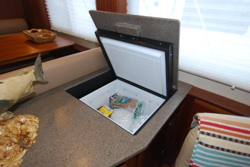 Slide: The Image of 2015 American Tug 485 interior with open built-in storage compartment on countertop. - 42