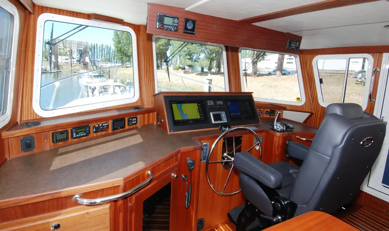 Slide: The Image of Pilothouse interior of 2015 American Tug 485, featuring navigation equipment and captain's chair. - 44