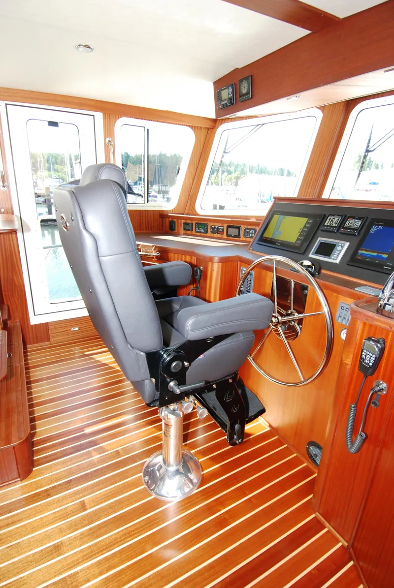 Slide: The Image of Pilothouse of 2015 American Tug 485 with modern controls and leather captain's chair. - 47