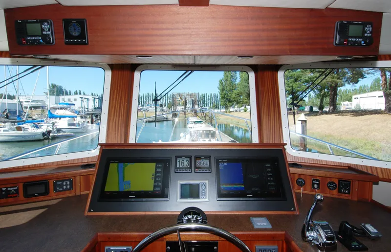 Slide: The Image of Pilothouse interior of 2015 American Tug 485, featuring navigation screens and controls. - 48