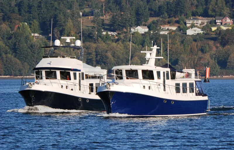 Slide: The Image of Two American Tug 485 boats cruising on a scenic waterway, 2015 model. - 7
