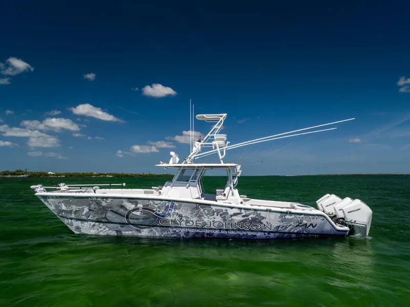 Slide: The Image of Freeman 37 VH 2023 boat on clear green water under blue sky. - 1