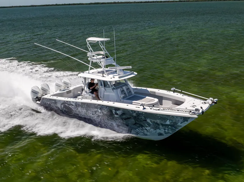 Slide: The Image of Freeman 37 VH 2023 boat speeding on clear green water, showcasing sleek design and powerful engines. - 10