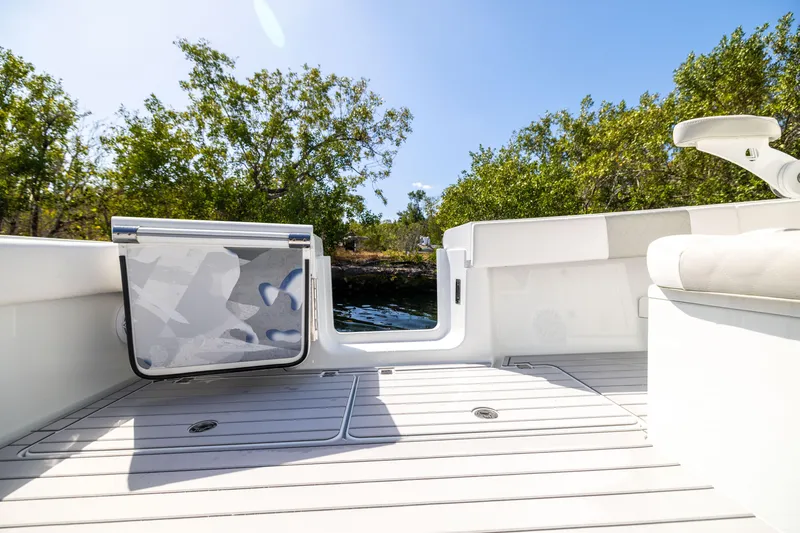 Slide: The Image of Freeman 37 VH 2023 boat deck with open door, surrounded by trees and water. - 27