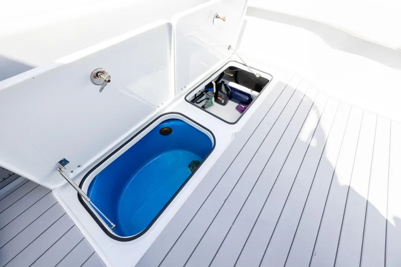 Slide: The Image of Storage compartments on 2023 Freeman 37 VH boat deck, featuring a blue livewell and gear storage. - 31