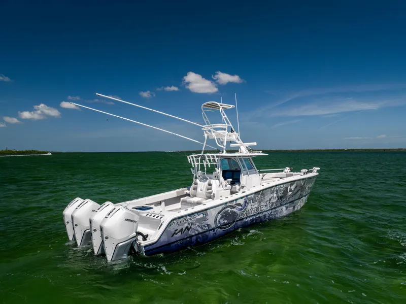 Slide: The Image of Freeman 37 VH 2023 boat with triple engines on green water under blue sky. - 4