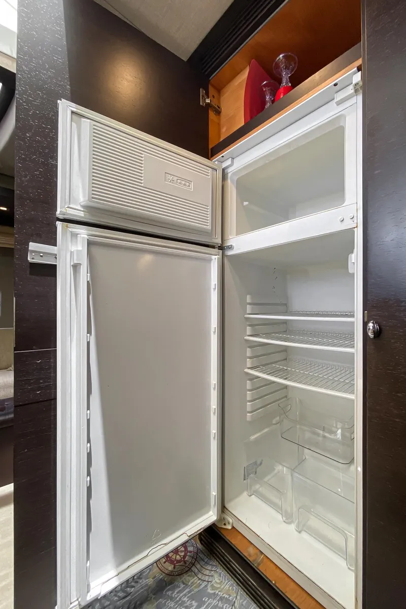 Slide: The Image of Open refrigerator inside 2009 Azimut 62S yacht, showcasing spacious interior and shelving. - 31