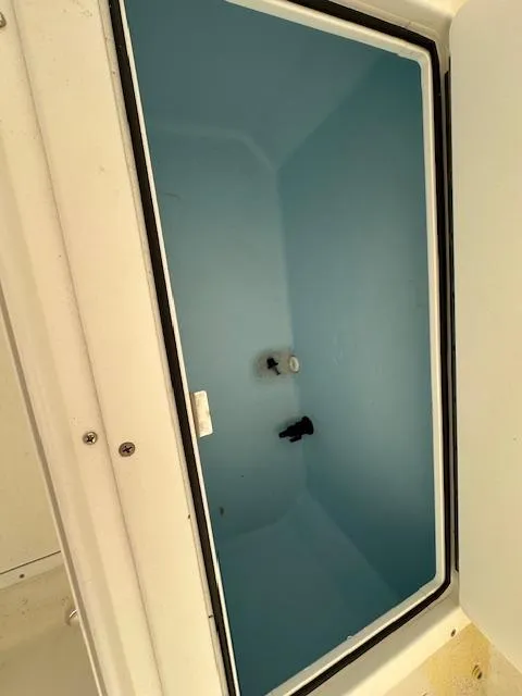 Slide: The Image of 2021 AmeraCat 27 Gen II DC boat storage compartment, open lid, blue interior. - 12