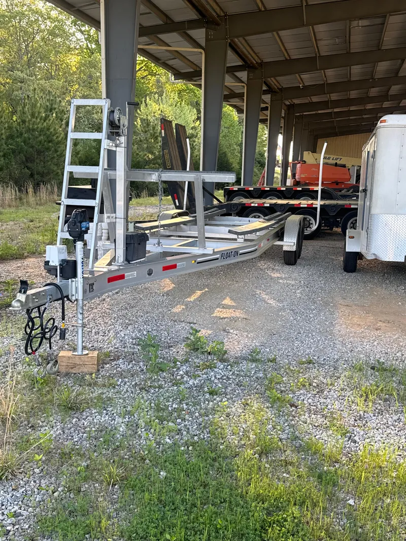 Slide: The Image of 2021 AmeraCat 27 Gen II DC boat trailer under a metal shelter, surrounded by greenery. - 45