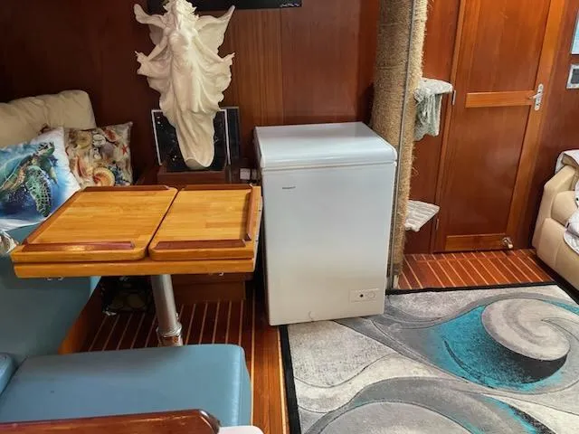 Slide: The Image of Interior of 2014 Seaton Custom Ketch with wooden table, fridge, and decorative sculpture. - 13