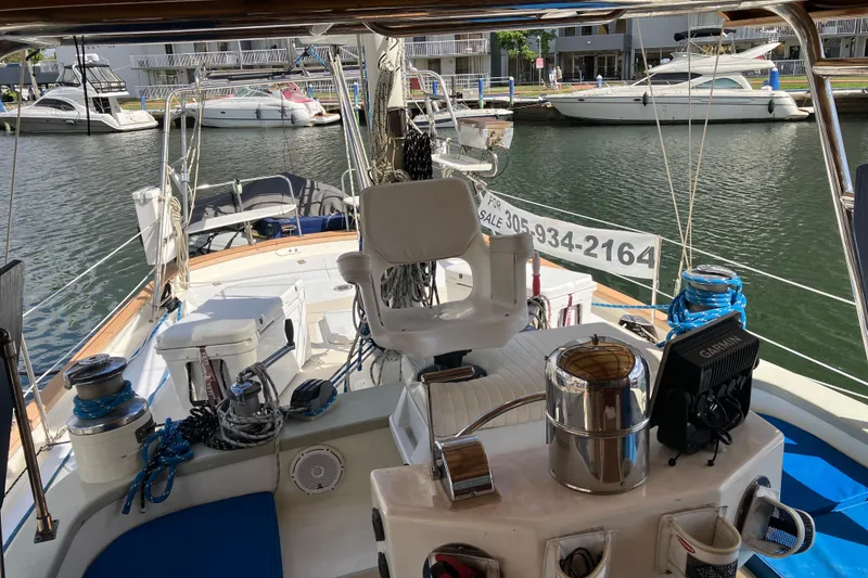 Slide: The Image of 2014 Seaton Custom Ketch sailboat docked, featuring navigation equipment and seating area. - 36