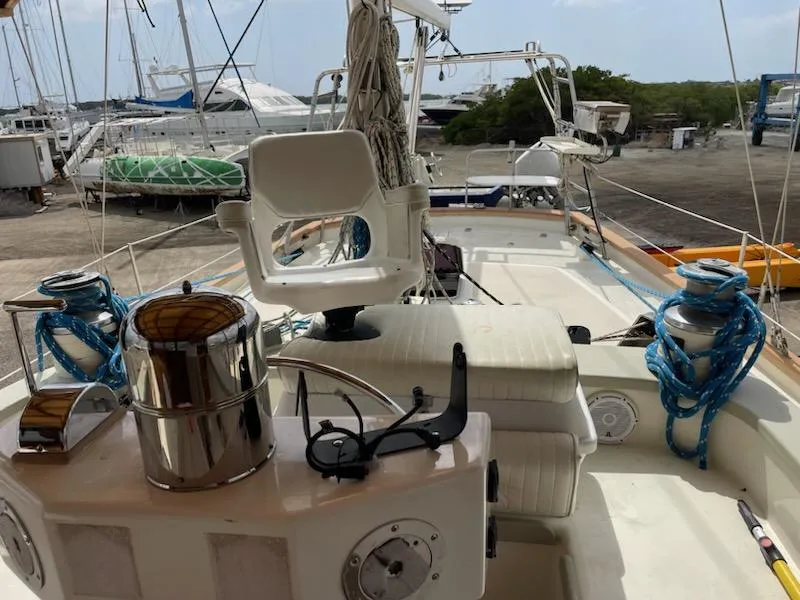 Slide: The Image of Seaton Custom Ketch 2014 sailboat deck with ropes and seating, docked at a marina. - 7