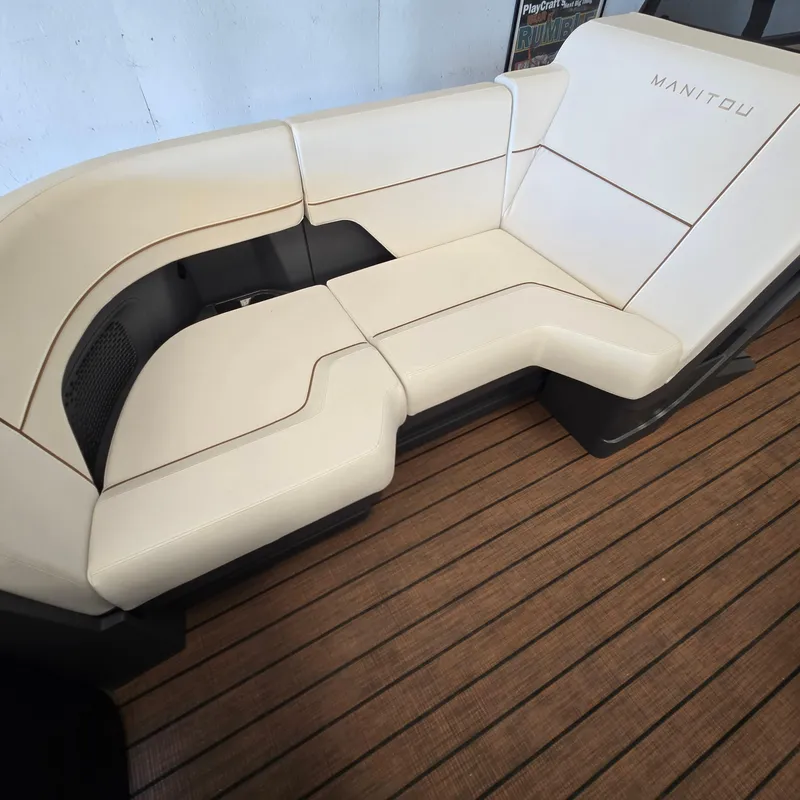 Slide: The Image of 2024 Manitou Explore 22+4 Switchback boat seating on wooden deck. - 14
