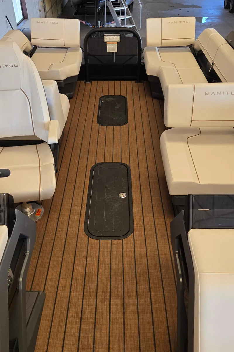 Slide: The Image of 2024 Manitou Explore 22+4 Switchback interior with spacious seating and wood-style flooring. - 15