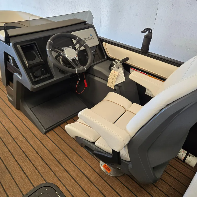 Slide: The Image of 2024 Manitou Explore 22+4 Switchback helm with steering wheel and comfortable seating. - 5