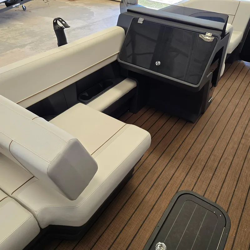 Slide: The Image of 2024 Manitou Explore 22+4 Switchback interior with beige seating and wood flooring. - 7