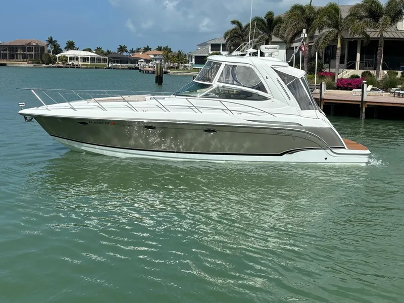 Slide: The Image of 2008 Formula 37 PC yacht on calm water near a dock with palm trees. - 11