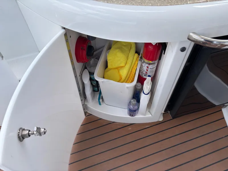 Slide: The Image of Open cabinet on 2008 Formula 37 PC boat with cleaning supplies and fire extinguisher. - 24