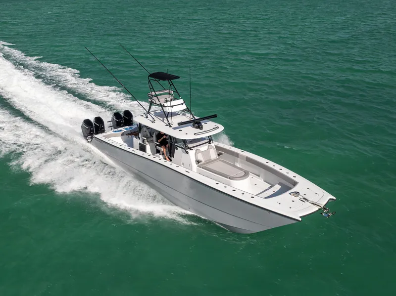 Slide: The Image of 2024 Freeman 42 LR boat cruising on turquoise water, showcasing sleek design and powerful engines. - 15