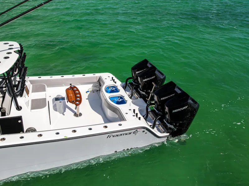 Slide: The Image of 2024 Freeman 42 LR boat with dual Mercury engines on turquoise water. - 16