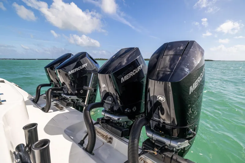 Slide: The Image of Four Mercury outboard engines on a 2024 Freeman 42 LR boat in clear blue water. - 17