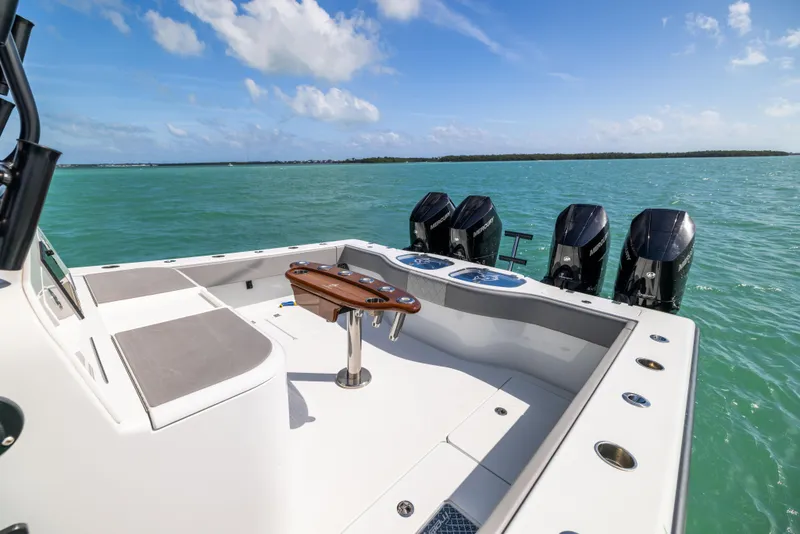 Slide: The Image of 2024 Freeman 42 LR boat with four engines on turquoise water under blue sky. - 24