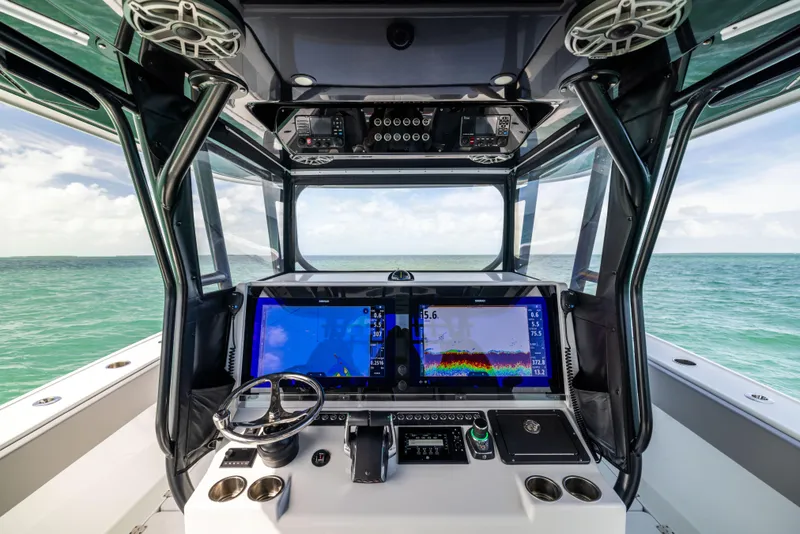 Slide: The Image of 2024 Freeman 42 LR boat cockpit with advanced navigation screens, steering wheel, and ocean view. - 42