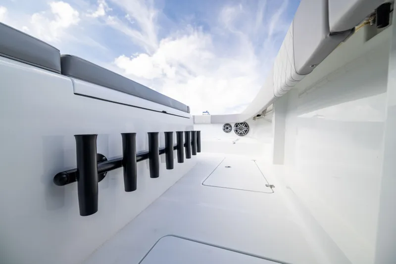 Slide: The Image of 2024 Freeman 42 LR boat interior with rod holders and seating under a blue sky. - 45