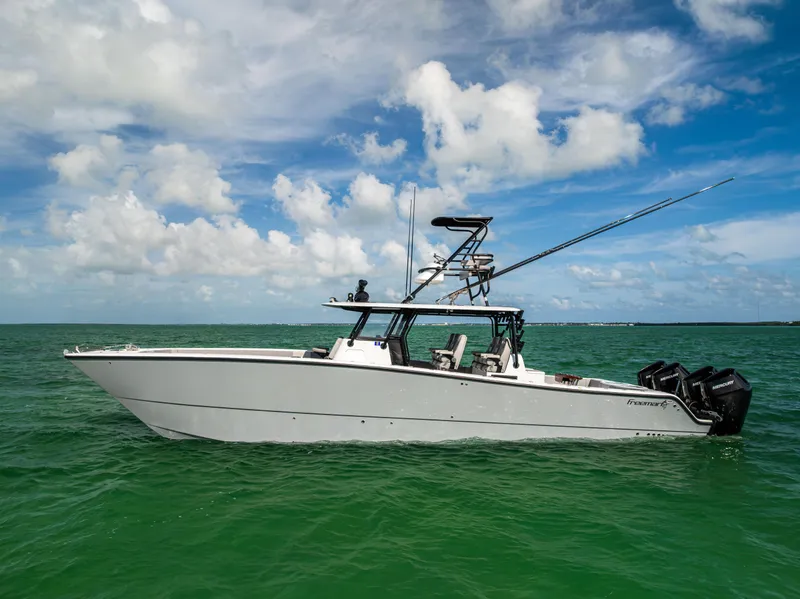 Slide: The Image of 2024 Freeman 42 LR boat on open water under a partly cloudy sky. - 6