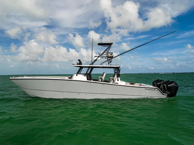 Slide: The Image of 2024 Freeman 42 LR boat on calm ocean waters under a partly cloudy sky. - 8