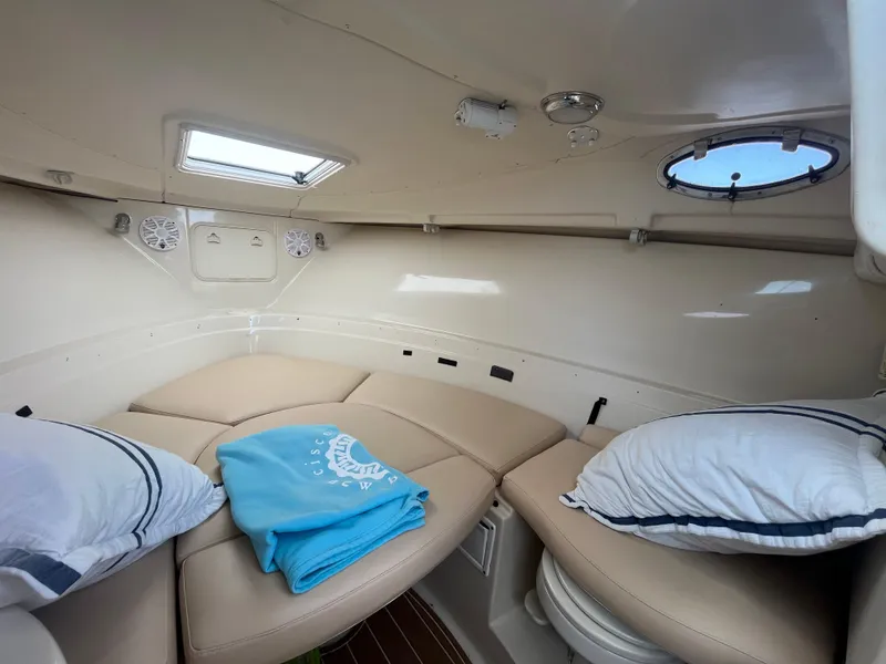 Slide: The Image of 2004 Wellcraft Coastal 252 cabin interior with cushions, pillows, and a skylight. - 10