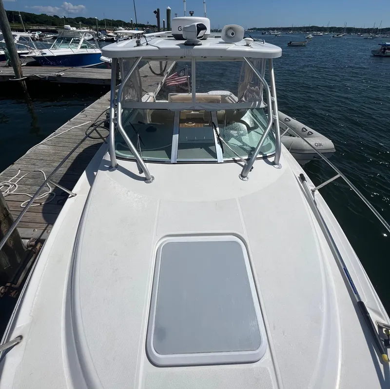 Slide: The Image of 2004 Wellcraft Coastal 252 boat docked at marina, sunny day, calm waters. - 13