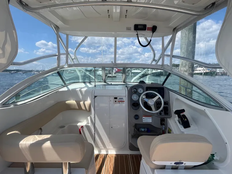 Slide: The Image of 2004 Wellcraft Coastal 252 boat interior with helm, seating, and water view. - 2