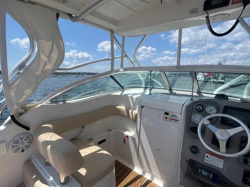 Slide: The Image of 2004 Wellcraft Coastal 252 boat interior with steering wheel, gauges, and seating under a sunny sky. - 4