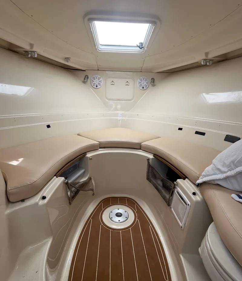 Slide: The Image of 2004 Wellcraft Coastal 252 cabin interior with beige seating and wood flooring. - 9