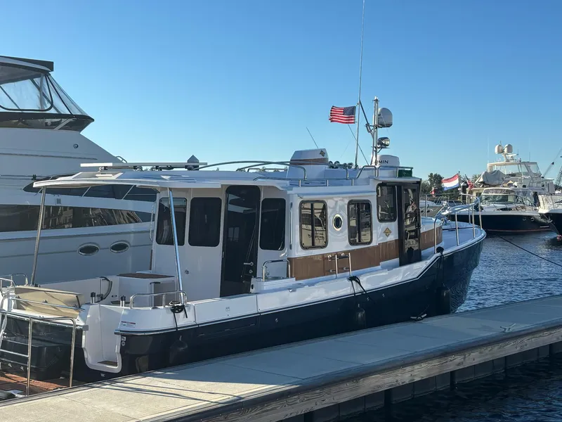 The Image of 2024 Ranger Tugs R31S docked at marina under clear blue sky. - 1