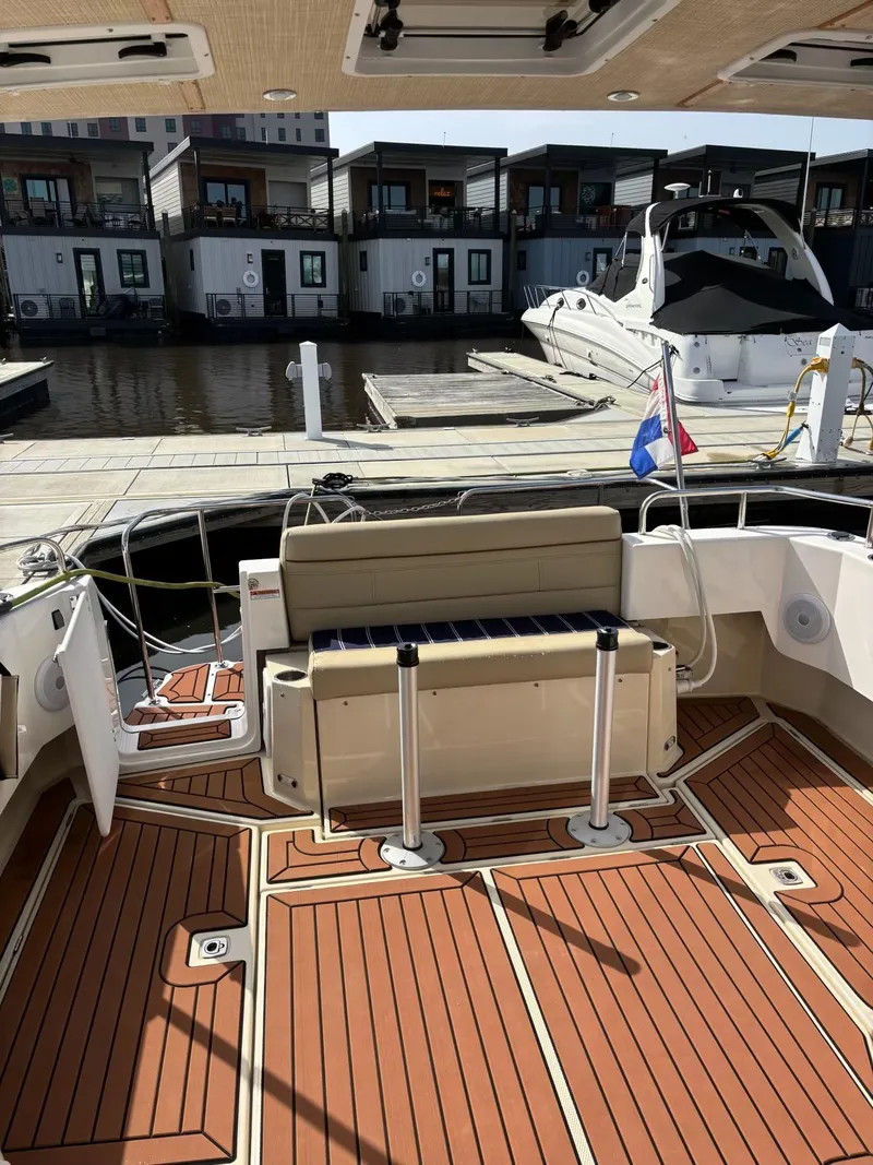Slide: The Image of 2024 Ranger Tugs R31S boat interior with wooden deck, docked at marina. - 12
