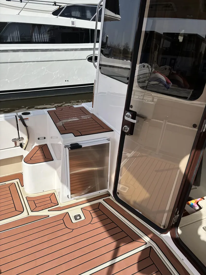 Slide: The Image of 2024 Ranger Tugs R31S boat deck with wood finish and glass door. - 13