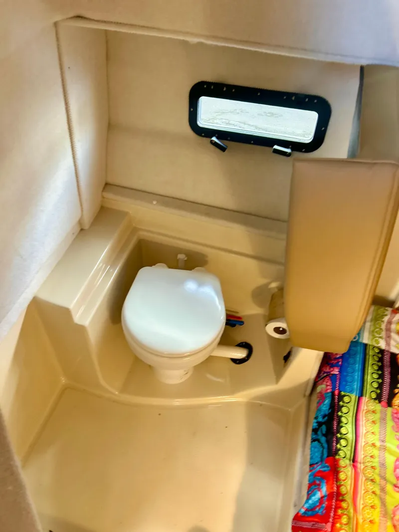 Slide: The Image of 2024 Ranger Tugs R31S boat interior bathroom with toilet and window. - 18