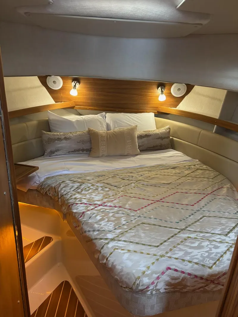Slide: The Image of 2024 Ranger Tugs R31S cabin with cozy bed and ambient lighting. - 24