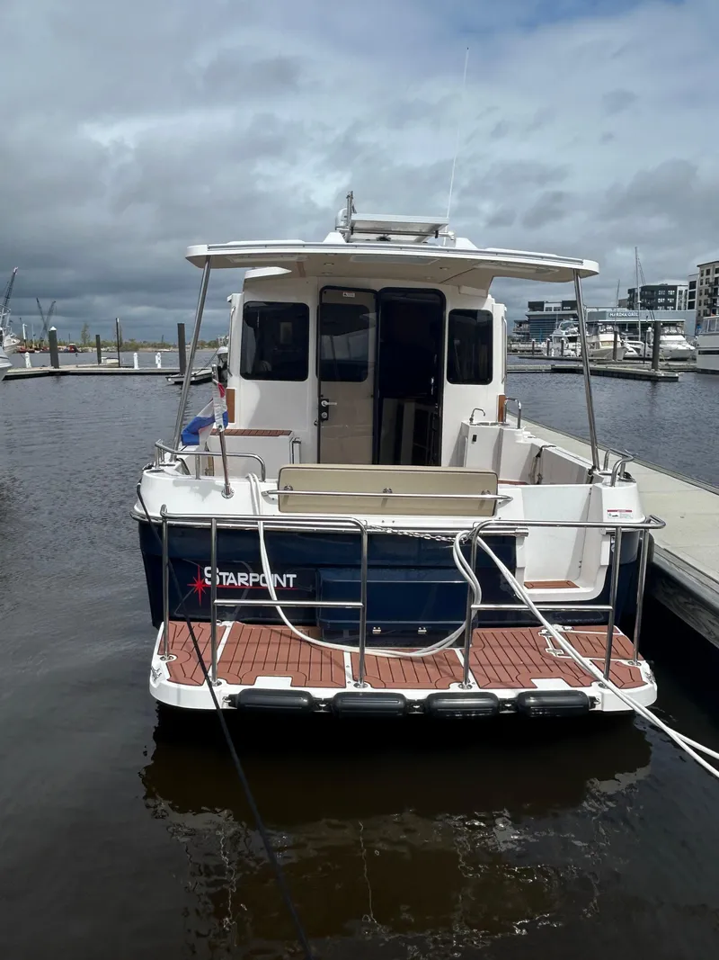 Slide: The Image of 2024 Ranger Tugs R31S docked at a marina under cloudy skies. - 26