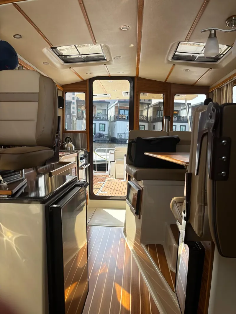 Slide: The Image of Interior of 2024 Ranger Tugs R31S, featuring elegant wood flooring and modern seating. - 3