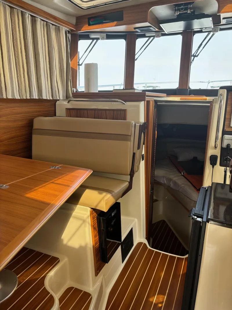 Slide: The Image of 2024 Ranger Tugs R31S interior with wood accents and seating area. - 5